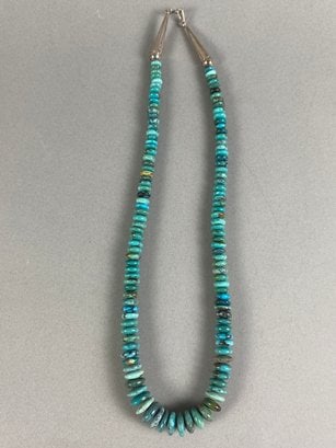 Native American Polished Turquoise Heishi Bead Necklace With Sterling Silver Accents By Joe: The necklace is in very good condition. The necklace appears to have polished turquoise heishi bead, but we are not certain of the material. The cone ends are marked 'Sterling' and have the Joe Tortal