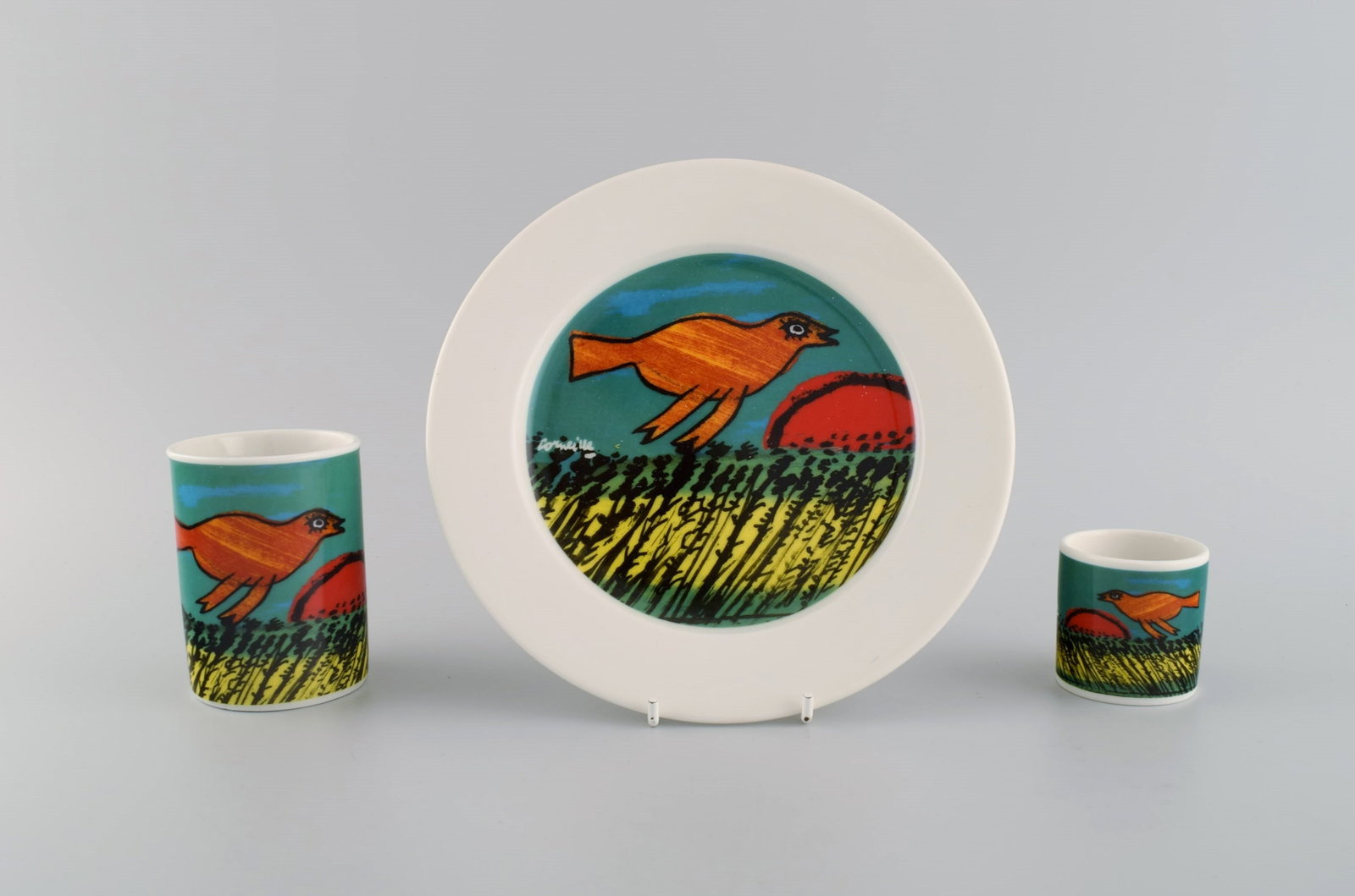 Corneille (Guillaume Cornelis van Beverloo), Dutch CoBrA artist (1922-2010). Coffee cup, plate and: Corneille (Guillaume Cornelis van Beverloo), Dutch CoBrA artist (1922-2010). Coffee cup, plate and egg cup in porcelain decorated with birds over field with sunrise. 1980s / 90s. The cup measures: 9 x