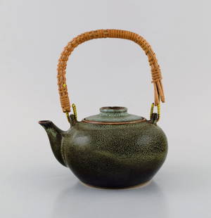 Chinese teapot in glazed stoneware with wicker handle. Beautiful speckled glaze in dark green and: Chinese teapot in glazed stoneware with wicker handle. Beautiful speckled glaze in dark green and turquoise shades. 20th century. Measures: 17.5 x 16 cm (incl. Handle). In excellent condition. Stamped