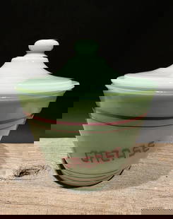 6" Jadeite Depression Glass Retro Grease Jar: 5 1/2" W x 6" H Reproduction never used jadeite green glass grease jar with a lid, often referred to as a grease drippings bowl. It features red stripes and the word "GREASE" printed on the front. The