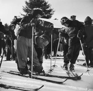 Slim Aarons 'New England Skiing' 1955 Oversize Silver Gelatin Print Framed In Black: Description Slim Aarons 'New England Skiing' 1955 Oversize Silver Gelatin Print Framed In Black Former ski instructor Herman Ostermaier gives a helping hand to a member of the Junior Skiing Program in