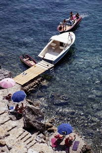 Slim Aarons 'Pellicano Beach' Oversize C Print Unframed: Description Boats at a jetty by the beach at the Hotel Il Pellicano in Porto Ercole, Tuscany, August 1969. (Photo by Slim Aarons). unframed C print 30x20" inches / 76 x 51 cm paper size Archive stampe