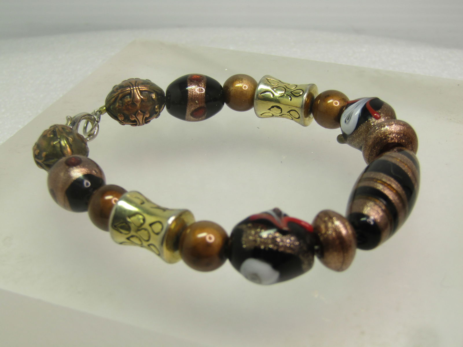 Black/Copper Art Glass Beaded Bracelet, 8", Murano Style, 1990's: Black/Copper Art Glass Beaded Bracelet, 8", Murano Style, 1990's. This has a center oblong black bead with glittery red and coppyer tone accents which many of the beads have, including some with red d