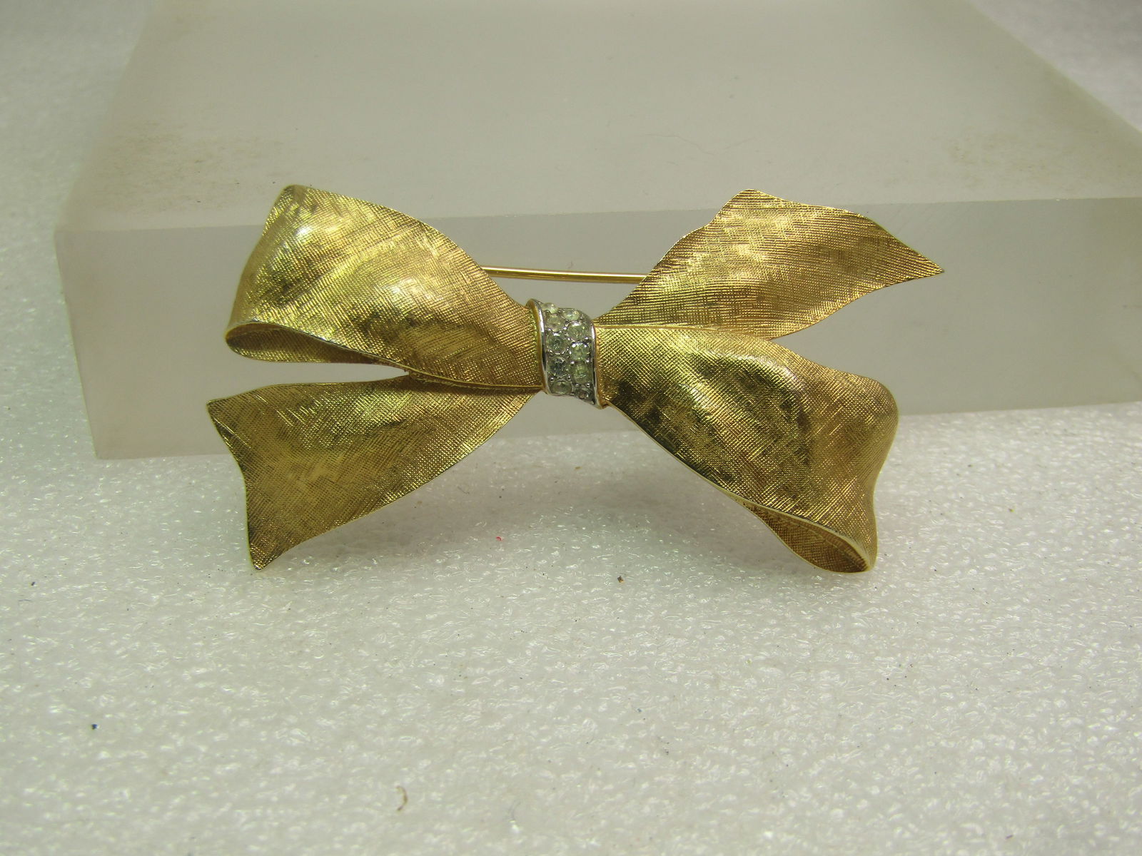 Vintage Two-Tone Bow Brooch, Rhinestones, Signed Trifari, 1960's-1970's: Vintage Two-Tone Bow Brooch, Rhinestones, Signed Trifari, 1960's-1970's. Gold tone textured finish with a looped bow and a center silver tone band that crosses the bow in the center at a slight angle