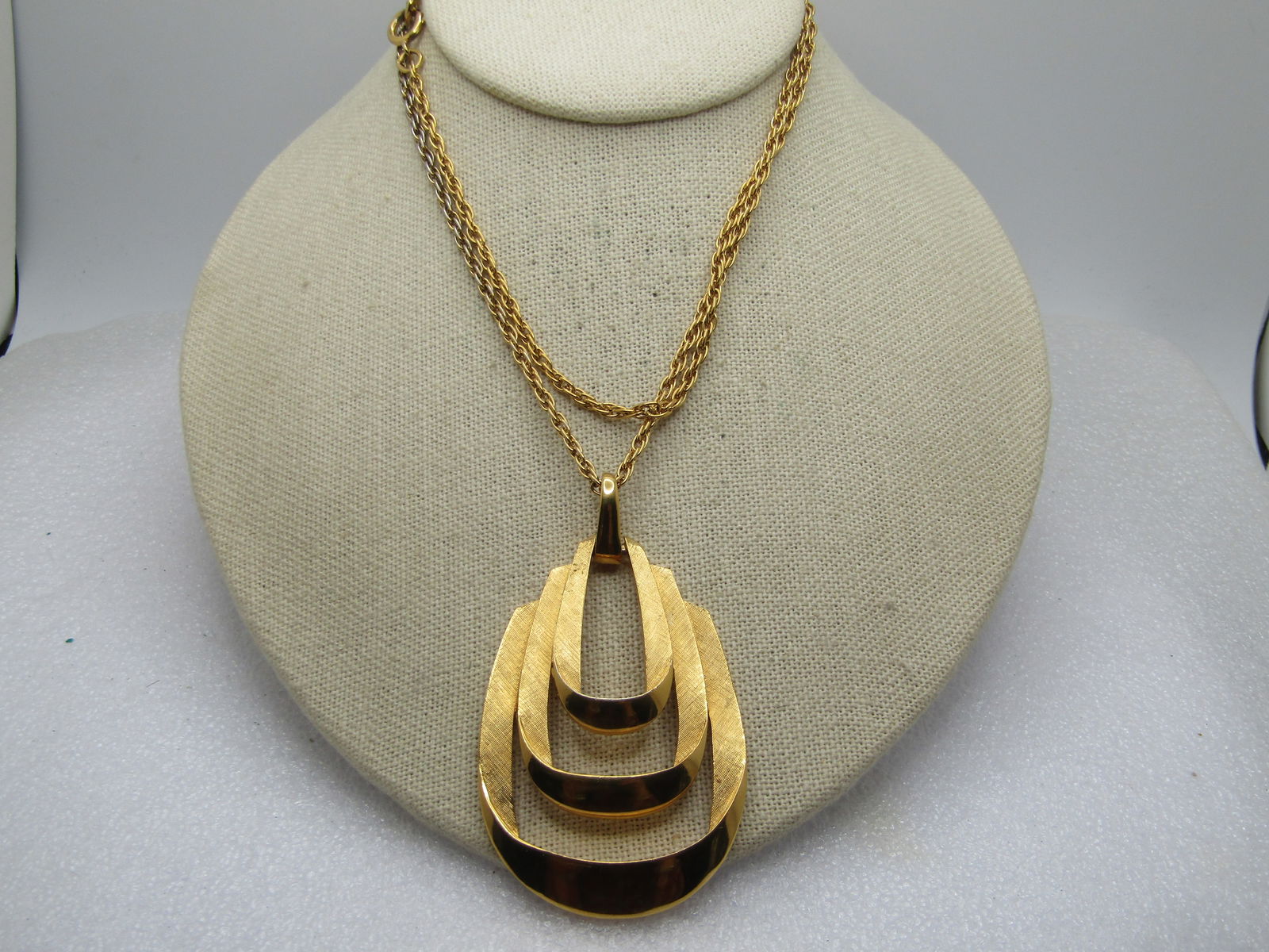 Vintage Crown Trifari Looped Pendant Necklace, 28", 1960's-1970's: Vintage Crown Trifari Looped Pendant Necklace, 28", 1960's-1970's. Gold tone with textured and smooth finish on the triple staggeredlooped pendant with smooth bail. The pendant is appx. 3" by 1.75". t