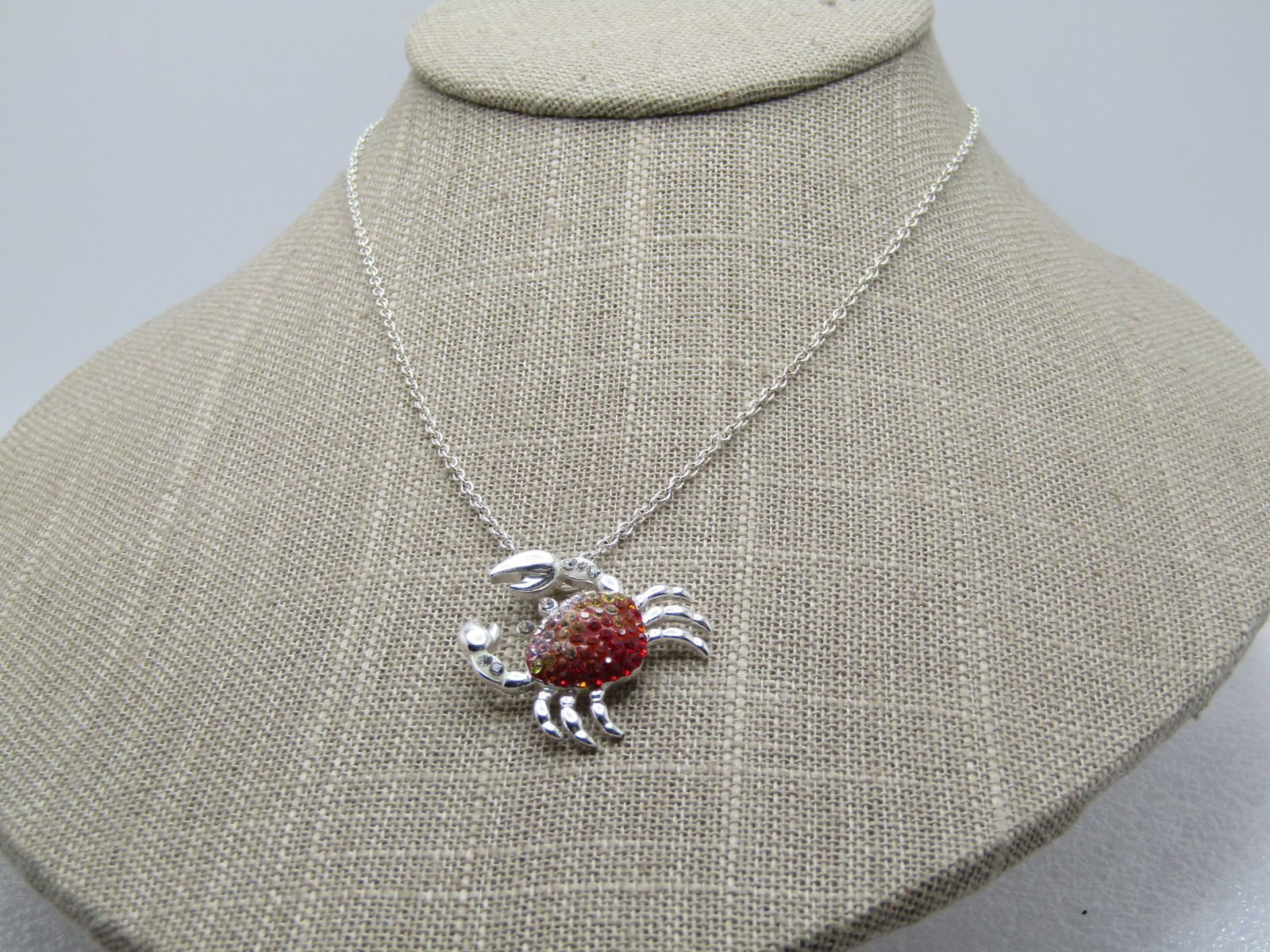 Rhinestone Crab Necklace, Signed JCM, Modern, 18": Rhinestone Crab Necklace, Signed JCM, Modern, 18" - Shades of red and orange and clear rhinestones on the shell and clear in the front claw area - It is silver tone and signed JCM which is Jacmel. The