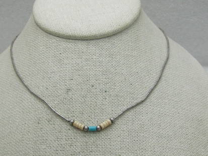 Sterling Southwestern Puka Turquoise Beaded Necklace 16": Sterling Southwestern Puka Turquoise Beaded Necklace 16". Straw liquid silver beads that are appx. 1mm wide with a centr of 8 puka shells and a single turquoise barrel bead with silver beads. The barr