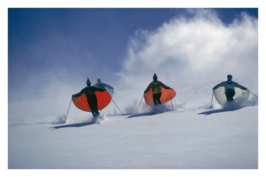Caped Skiers' Slim Aarons: Description Caped Skiers Photo by Slim Aarons 1967 Led by skimaster Stein Eriksen, skiers ‘sail’ down a slope at Snowmass-at-Aspen, Colorado, circa 1967. The skiers are wearing thin capes