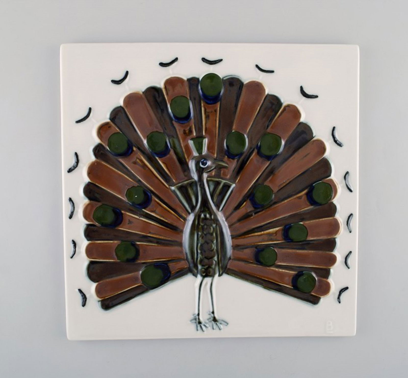 Bertil Lundgren for Rörstrand. "Gallery 2" wall plaque in glazed porcelain decorated with: Bertil Lundgren for Rörstrand. "Gallery 2" wall plaque in glazed porcelain decorated with peacock. 1970's. In very good condition. Measures: 25 x 25 cm. Stamped. Reserve: $175.00 Shipping: Domestic: