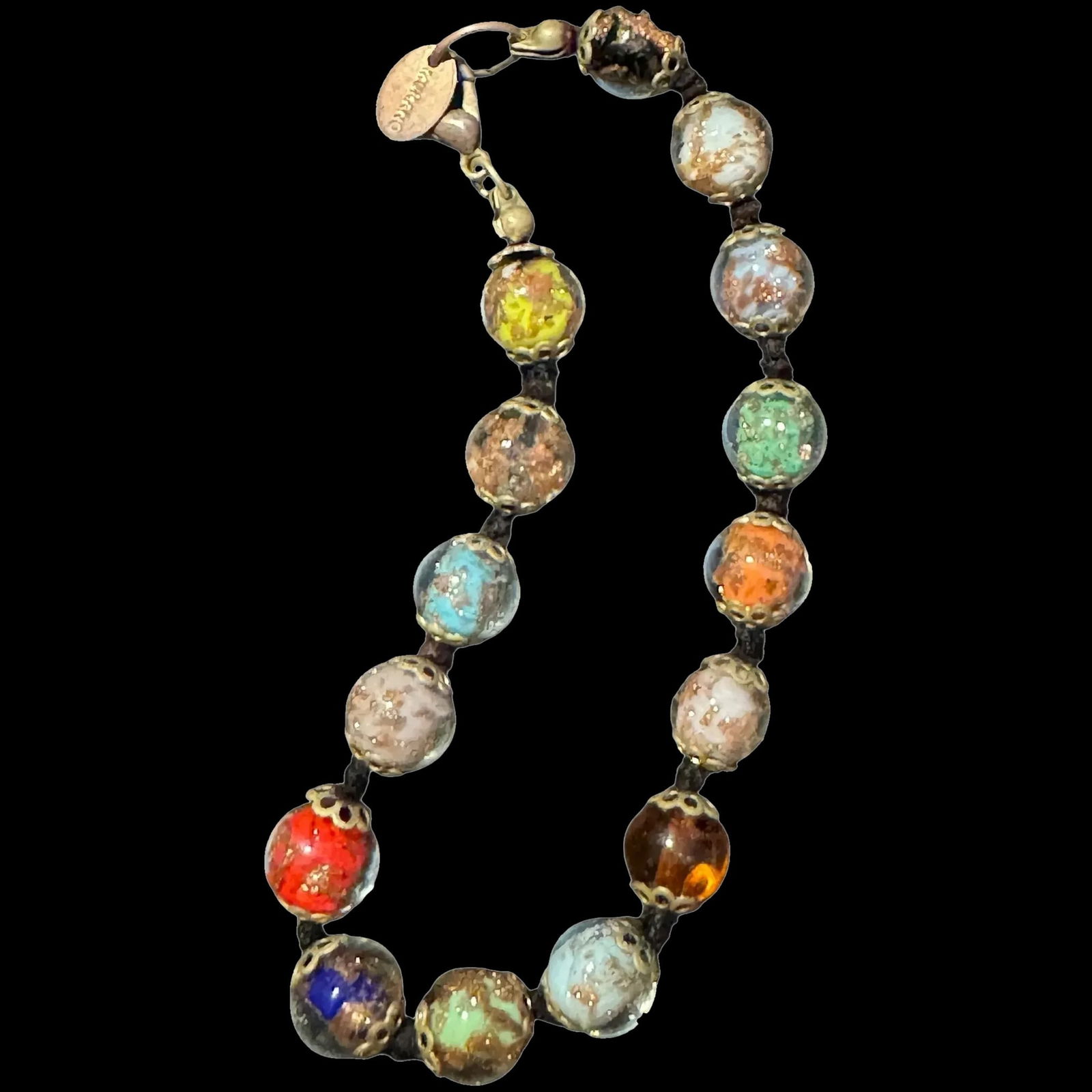 Vintage Murano Glass bracelet Italy: Murano glass bracelet featuring a variety of colorful glass beads connected by a cord and secured with a lobster claw clasp. Murano glass is handmade in Venice, Italy, using techniques that are centur