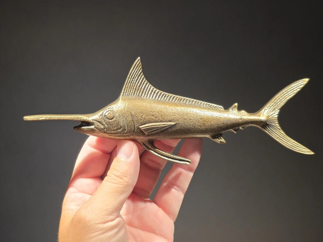 8 3/4" Swordfish Fish Letter Opener: – 8-3/4″ L x 3-1/2″ W x 1″ H – Weighs 5 oz Reproduction Vintage-style swordfish paperweight, crafted from lightweight aluminum with an antiqued brass finish. Perfect as a