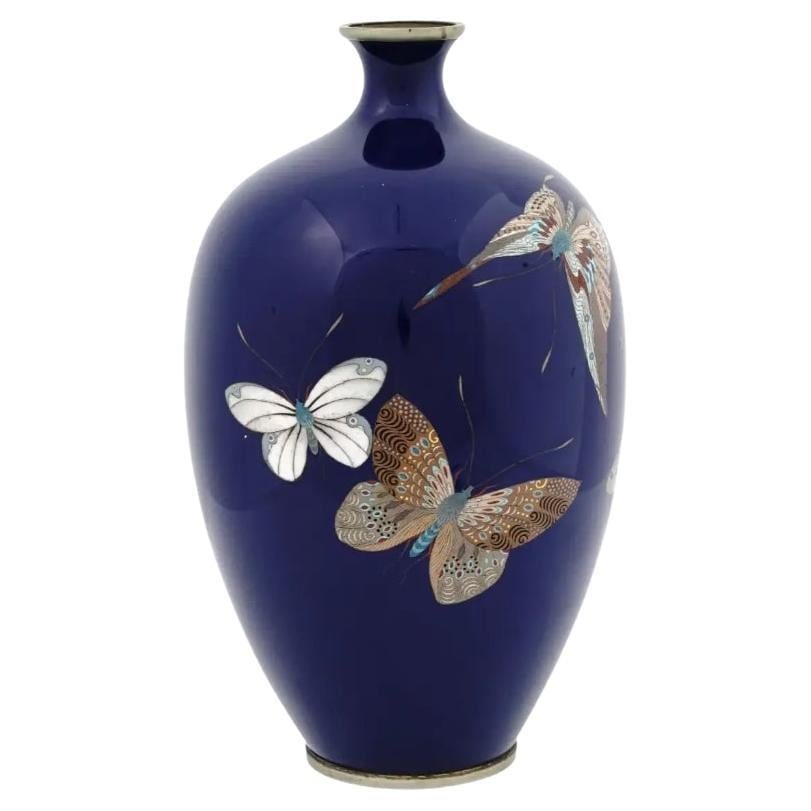 Large Antique Japan Meiji Butterflies Cloisonne Enamel Vase: About the Item A large antique Japanese Meiji period enamel vase. The vase has an amphora shaped body and a narrow neck. The vase is enameled with a polychrome image of butterflies made in the Cloison