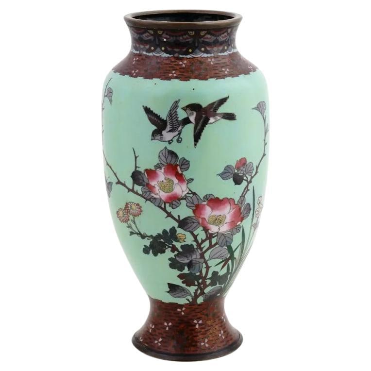 Large Antique Meiji Japanese Cloisonne Enamel Green Vase Flowers and Birds: About the Item A large antique Japanese late Meiji period enamel over brass vase. The vase has an amphora shaped body and a wide neck. The ware is enameled with a polychrome image of birds in blossomi