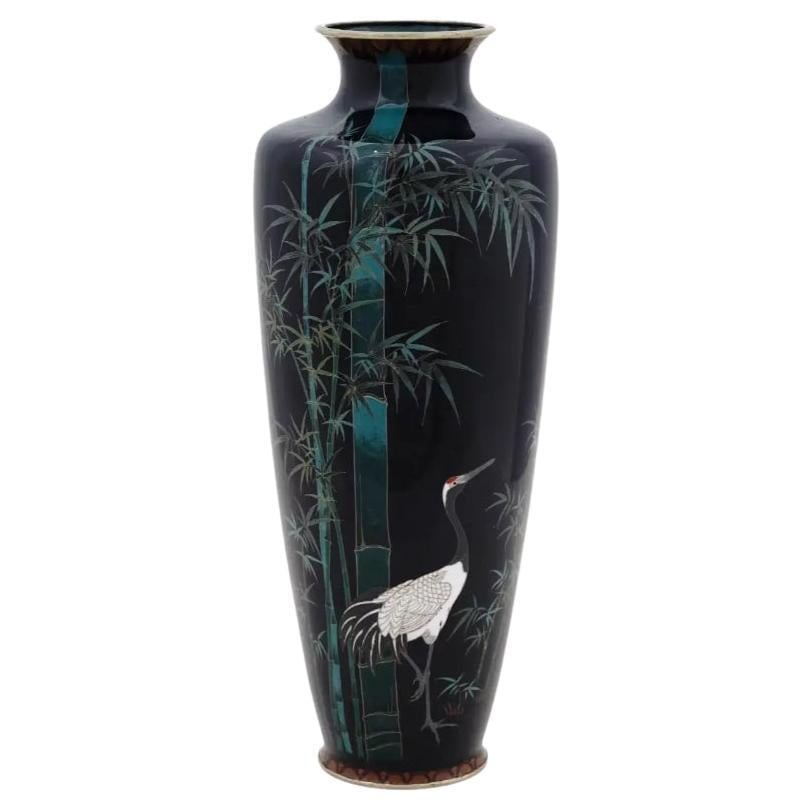 Large Antique Meiji Japanese Cloisonne Enamel Vase Crane in Bamboo Field: About the Item An antique Japanese, late Meiji period, enamel over brass vase. The vase has an amphora shaped body and a fluted neck. The ware is enameled with a polychrome image of a crane in bamboo