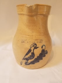 Marked stoneware pitcher with a great bird and branch