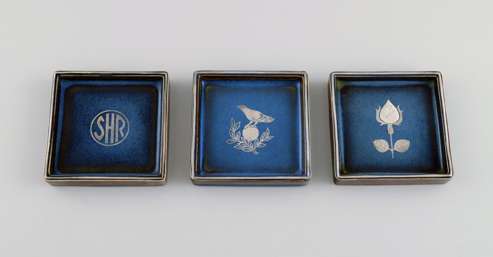Sven Jonson (1919-1989) Gustavsberg. Three small Lagun dishes in glazed stoneware with silver inlay.: Sven Jonson (1919-1989) Gustavsberg. Three small Lagun dishes in glazed stoneware with silver inlay. Beautiful glaze in shades of blue. 1970s. Measures: 9 x 9 x 1.5 cm. In excellent condition. Stamped
