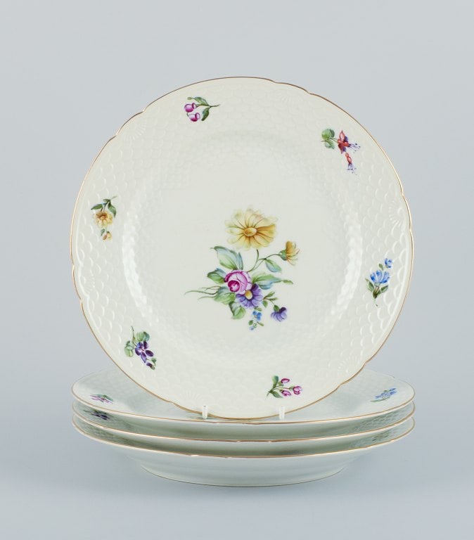 Bing & Grøndahl, Saxon Flower, a set of four dinner plates hand-decorated with polychrome: Bing & Grøndahl, Saxon Flower, a set of four dinner plates hand-decorated with polychrome flowers and gold rim. Approximately from the 1930s. Model number 25. Marked. First factory quality. In go