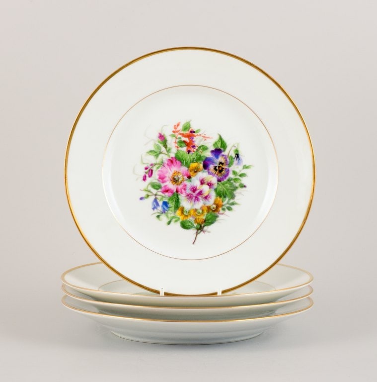 Bing & Grøndahl, four dinner plates in porcelain hand-painted with polychrome flowers and gold: Bing & Grøndahl, four dinner plates in porcelain hand-painted with polychrome flowers and gold decoration. Approx. 1920/30s. In excellent condition. Marked. First factory quality. Dimensions: D 2