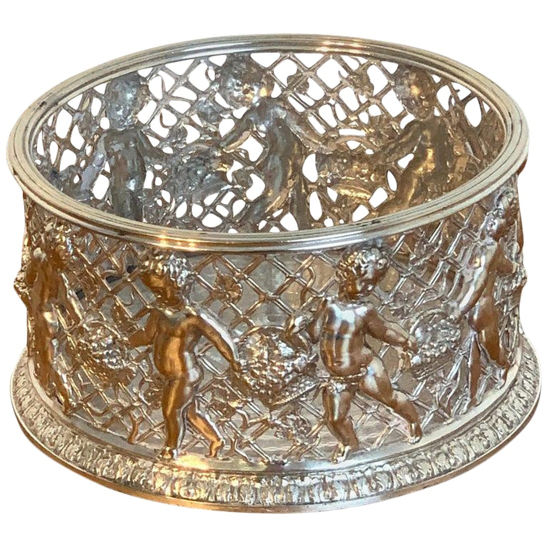 Late 19th Century English Silver Plated Putti Motif Large Wine Coaster, Elkington: Magnificent English silver plated putti motif large wine coaster, attributed to Elkington. With pierced body with 9 frolicking draped babes with baskets of flowers, engine turned bottom with mahogany