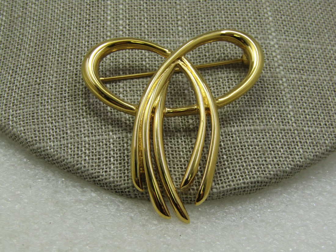 Vintage Crown Trifari Looped Bow Brooch, 2": Vintage Crown Trifari Looped Bow Brooch, 2" by 1.75". It has a solid pretzel-like looped bow with three strands coming off to the left and two to the right. Signed Crown Trifari, gold tone, appx. 1970