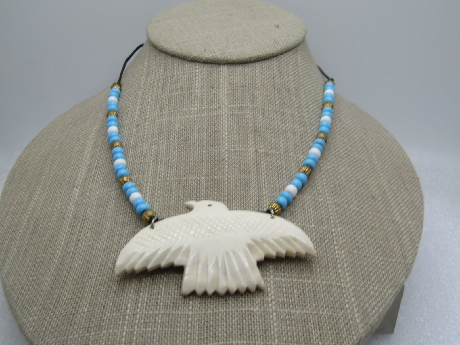 Vintage Carved Bone Thunderbird Necklace, 22", Southwestern. 1970's-1980's: Vintage Carved Bone Thunderbird Necklace, 22", 1970's-1980's. Southwestern necklace. The thunderbird si appx. 2.5" wide and 1.5" tall. Turquoiseand white glass large seed beads attach to each top of t