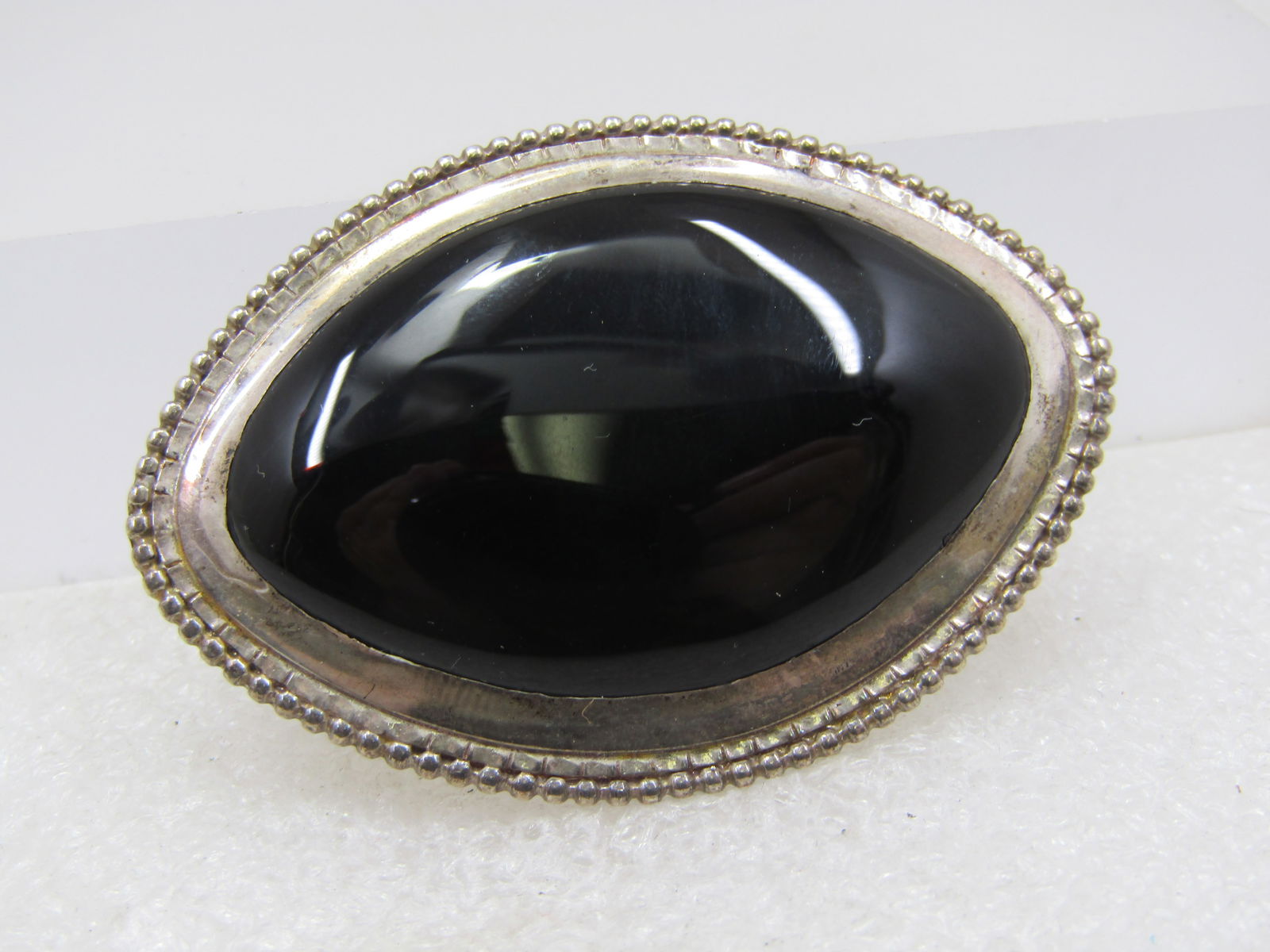 Vintage Southwestern Sterling Onyx Brooch, Signed I.C.2-1/8": Vintage Sterling Onyx Brooch, Signed I.C.2-1/8" by 1.5". It is a wide cateye shaped stone bezel set onyx that is appx. 42mm by 28mm. There is silver beaded accent around the frame. It is marked sterli