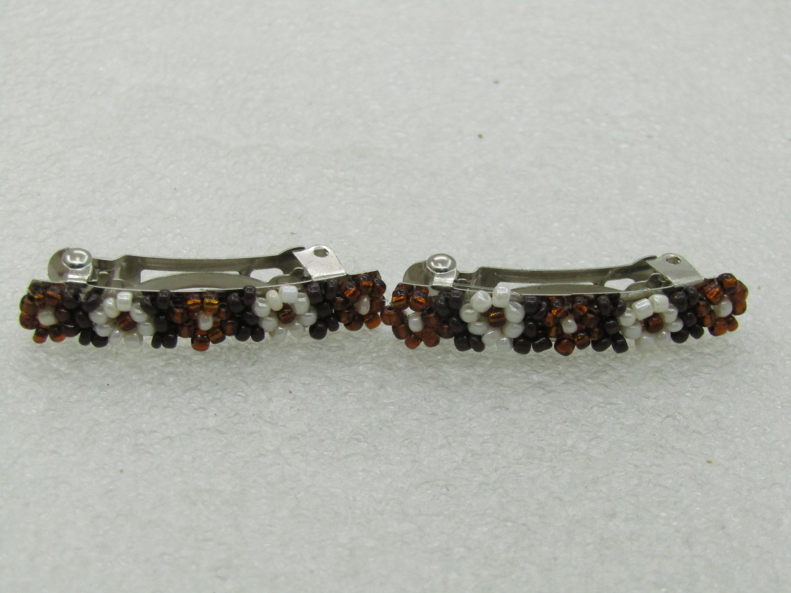 Vintage Pair Black, Copper White Beaded Barrettes, Southwestern Appeal, 1.5": Vintage Pair Black, Copper White Beaded Barrettes, 1.5" long and 1/3" wide". Southwestern Appeal. Copper, white, and blacked glass seed beads arranged in five blossoms on top. They are not marked or s