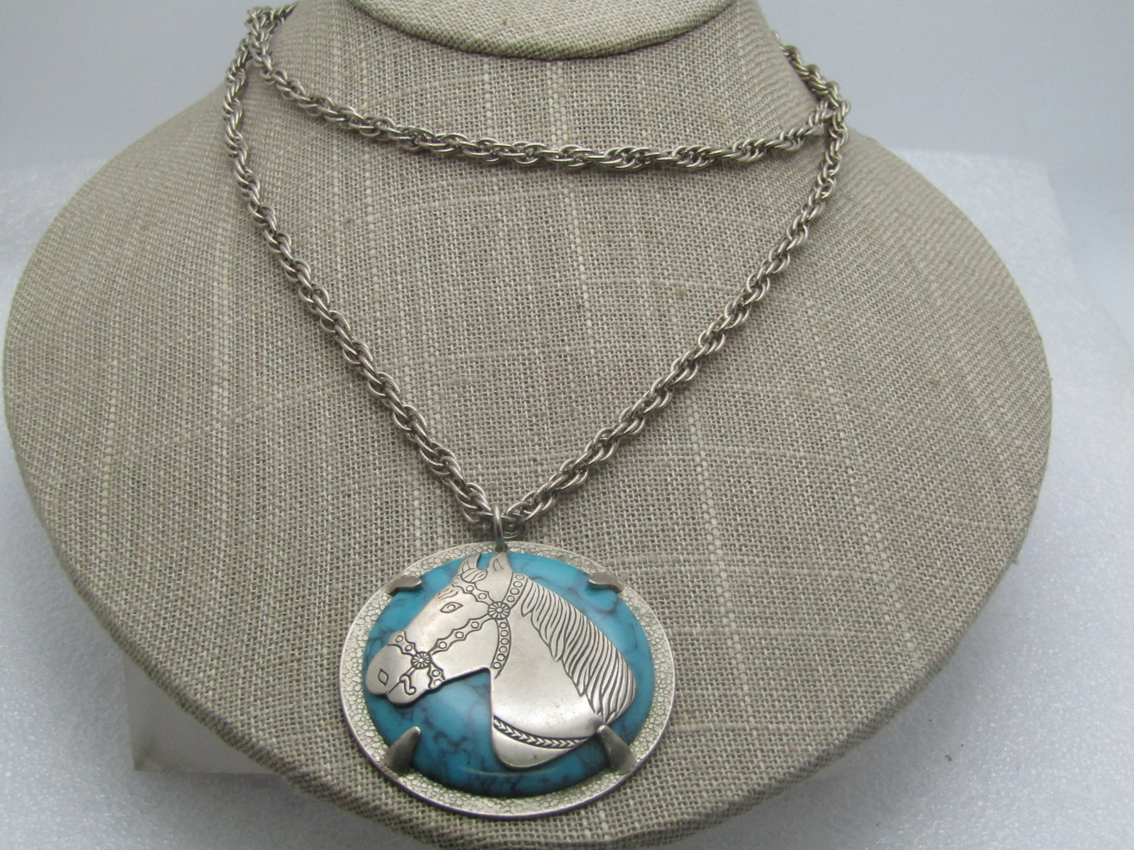 Vintage Faux Southwestern Turquoise Horse Necklace, Bell Nickel Silver , 28", 1960's.: Vintage Faux Southwestern Turquoise Horse Necklace, Bell Nickel Silver , 28". The pendant has a fuax turquoise cabochon in the center with a horsehead mounted over with carved - or pressed- design wit