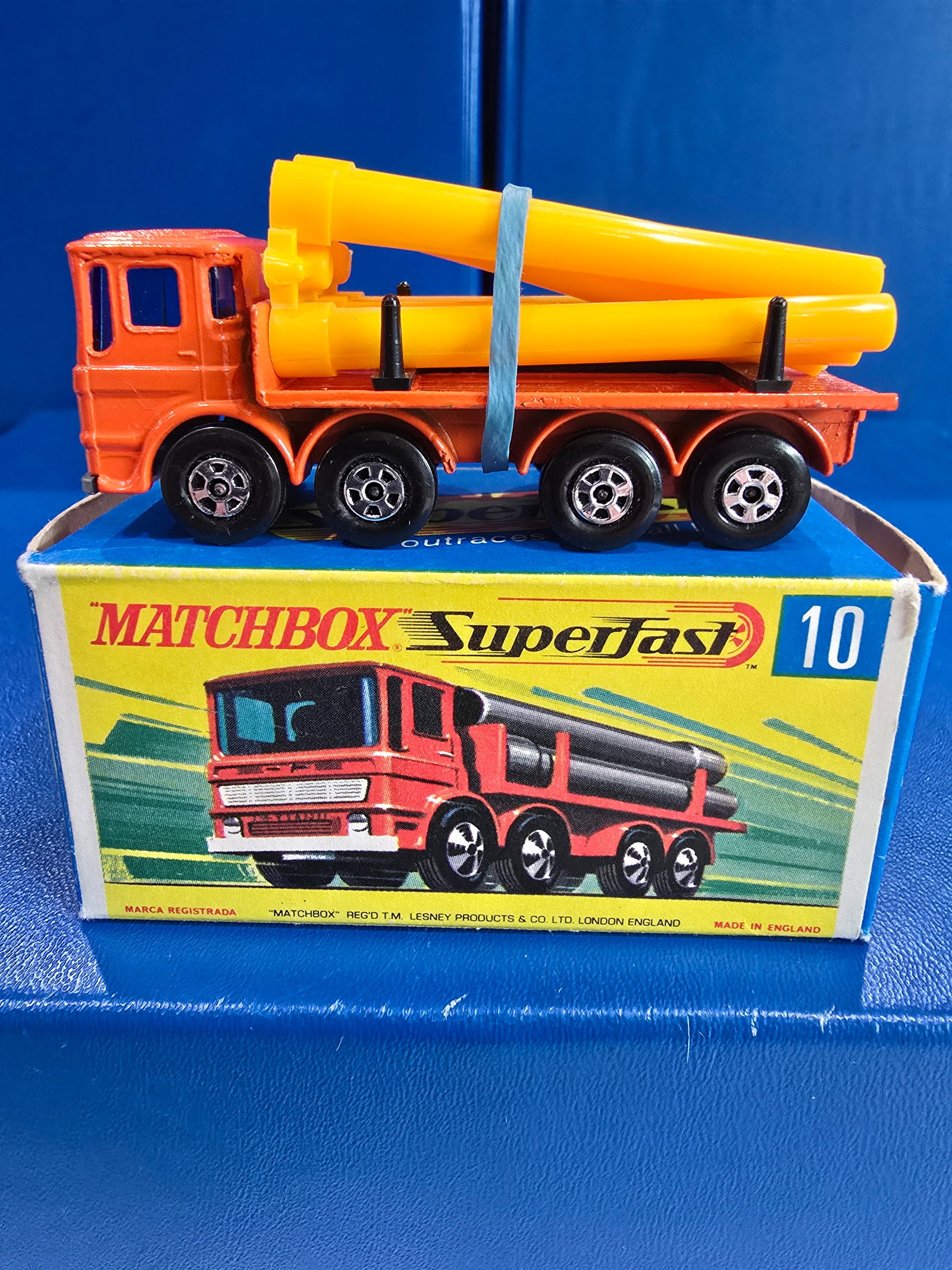 #10 Pipe Truck, Transitional wheels, yellow pipes on spru, orignal rubber band, orange body grey: Title: Matchbox Superfast - G BoxDescription: #10 Pipe Truck, Transitional wheels, yellow pipes on spru, orignal rubber band, orange body grey England base, b;ack axel clipsDate/Period: 1970.sMaterial