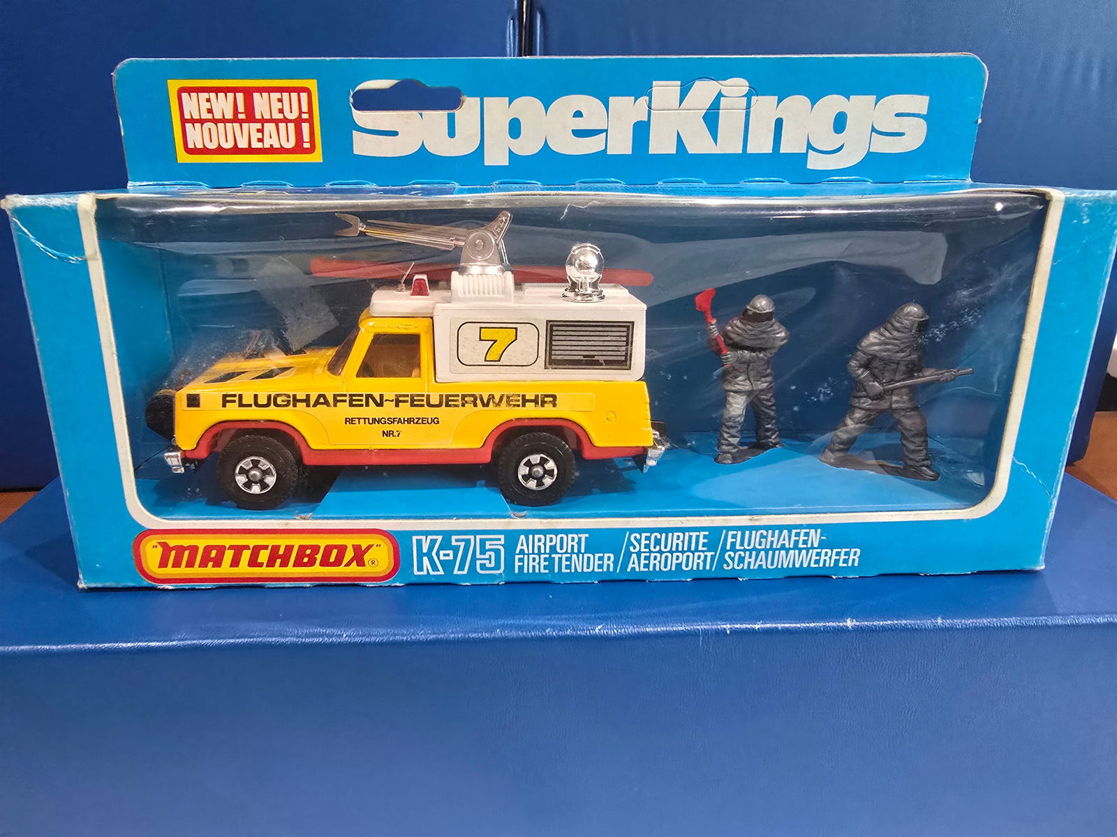 K-75 Airport Fire Tender, England base, unpunched box, rollup door lable: Title: Matchbox Super Kings - German Issue - Variation Description: K-75 Airport Fire Tender, England base, unpunched box, rollup door lableDate/Period: 1979Materials: MetalDimensions: 1/43 Reserve: $