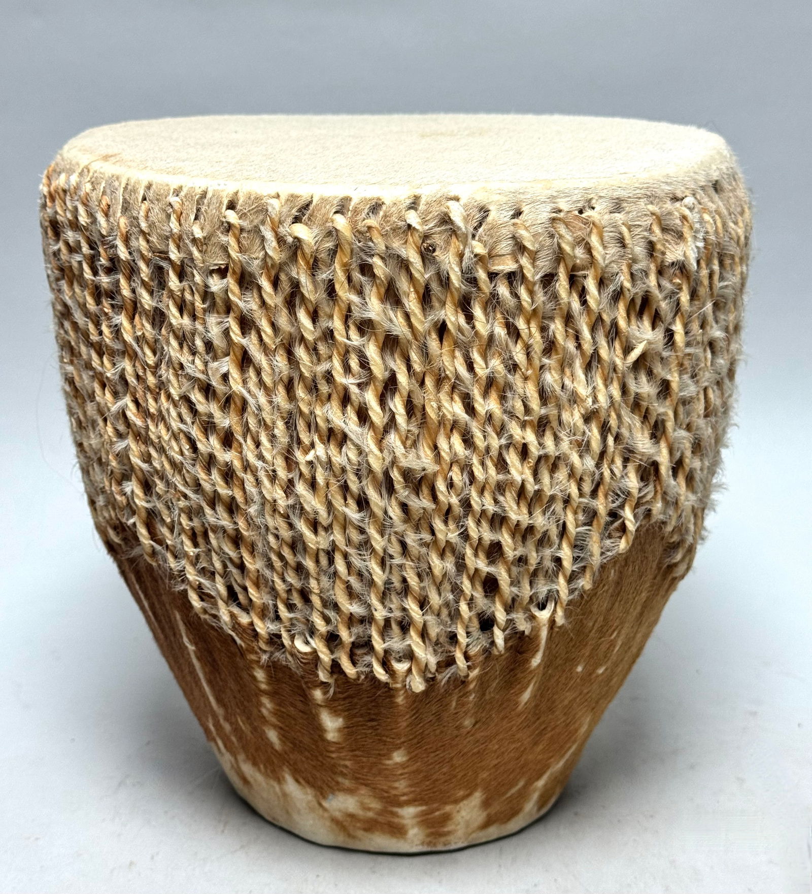 Hide-covered Carved Wood Drum - Zulu - South Africa: outh African Hide-covered Carved Wood Drum, Zulu, tapered toward the base and covered with multiple twisted hide ties. Perfect sound and very good to play. 22 x 22 x 22 cm Weight 1066 gram. Careful re