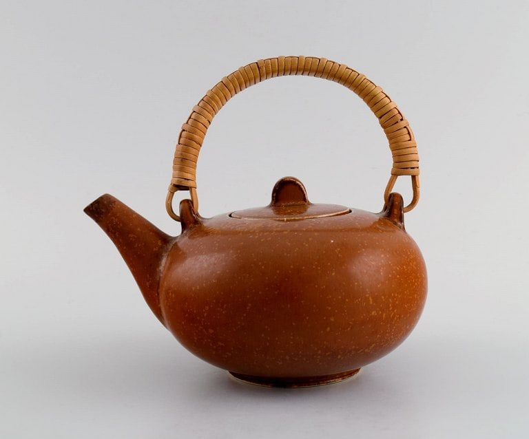 Eva Stæhr-Nielsen for Saxbo. Glazed stoneware teapot with wicker handle. Beautiful glaze in: Eva Stæhr-Nielsen for Saxbo. Glazed stoneware teapot with wicker handle. Beautiful glaze in red-brown shades. Mid 20th century. Measures: 16.5 x 15 cm (incl. handle). In excellent condition. Stam