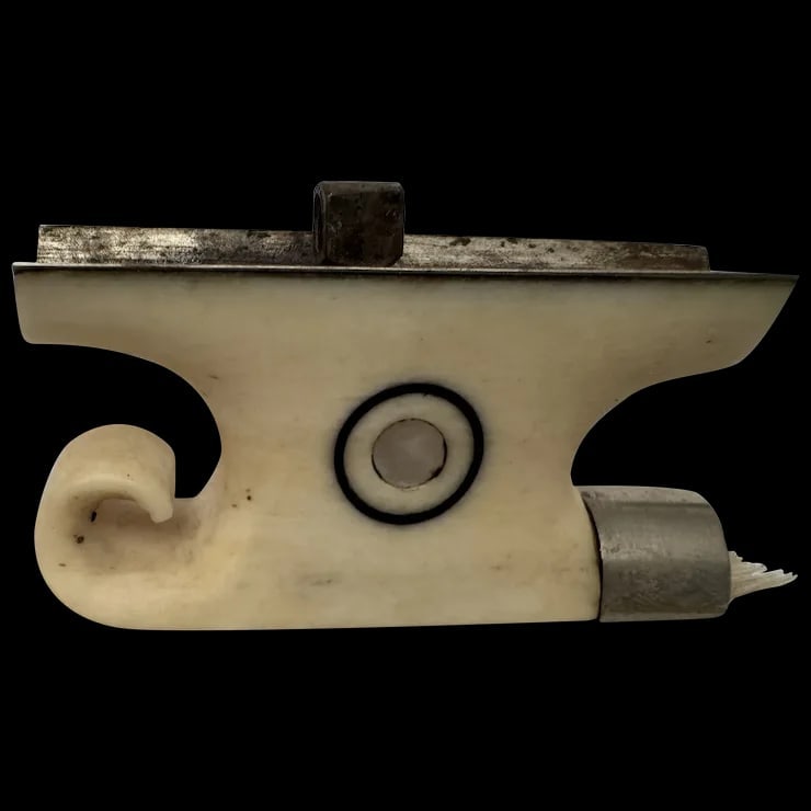 Antique original fancy frog for a violin bow: Antique original fancy frog for a violin bow. Dates back well over 100 years old. Has an ornate snail, "S" design. T is a mother of pearl section on the top and inlaid on both sides. Measures approxim
