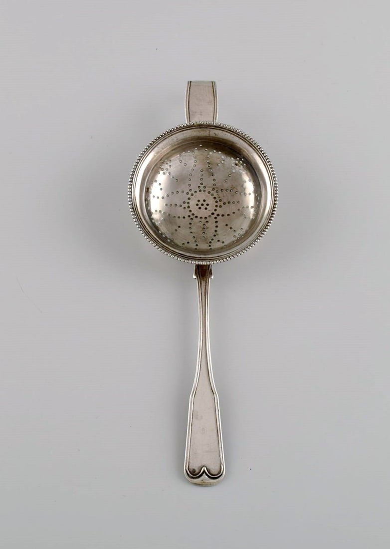 Danish silversmith. Antique silver (830) tea strainer. Dated 1852.: Title:Danish silversmith. Antique silver (830) tea strainer. Dated 1852. Description:Danish silversmith. Antique silver (830) tea strainer. Dated 1852. Length: 19 cm. In excellent condition. Stamped.