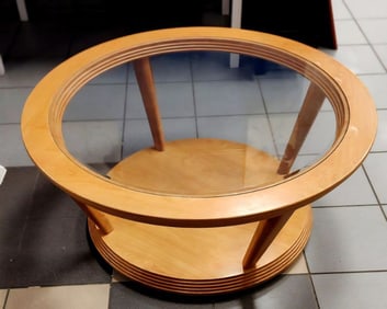 Stylish mid-century modern round coffee table on casters w/ glass top and a lower level.