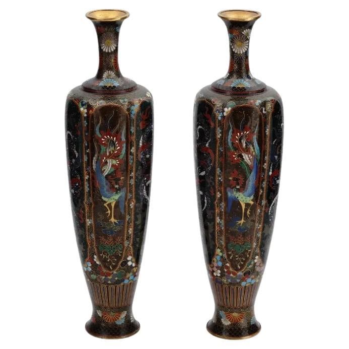 Rare High Quality Pair of Meiji Japanese Cloisonne Enamel Vases Dragons and Hoho: A pair of high quality symmetrical Japanese, Meiji era, enamel over brass vases. Each vase has an amphora shaped body and a tall narrow neck. The ware is enameled with polychrome panels depicting Phoe