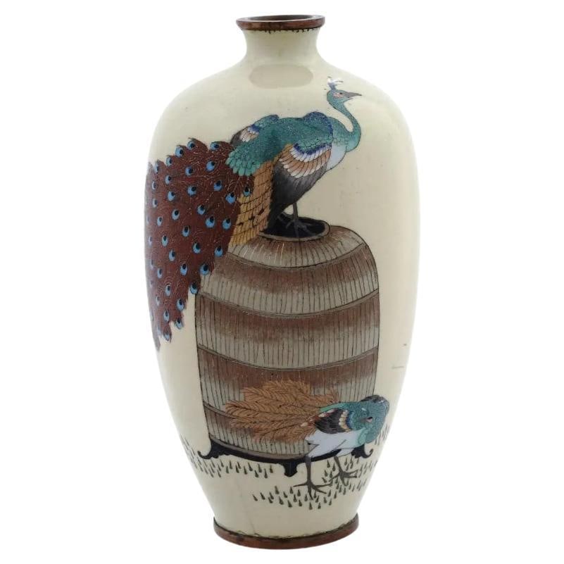 Antique Meiji Japanese Cloisonne Enamel With Pair of Peacocks: An antique Japanese Meiji period enamel over brass vase. The vase has an amphora shaped body and a narrow neck. The vase is enameled with a polychrome scene with a pair of peacocks made in the Cloison