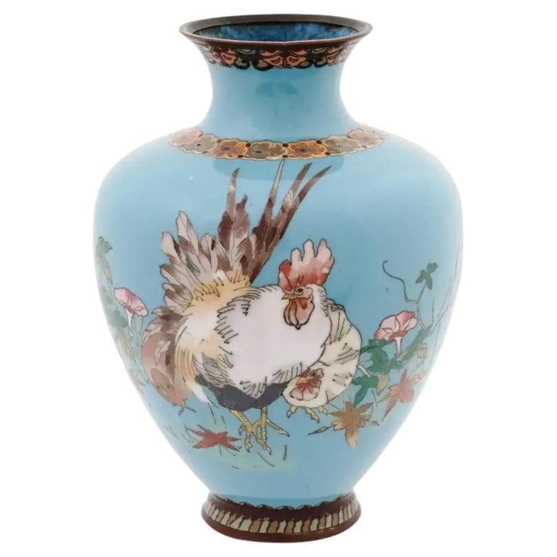 Antique Meiji Japanese Cloisonne Enamel Rooster Vase: A large Japanese amphora shaped enamel over brass vase. The vase is enameled with polychrome images of a rooster and a hen in flowers and leaves made in the Cloisonne technique on turquoise ground. Th