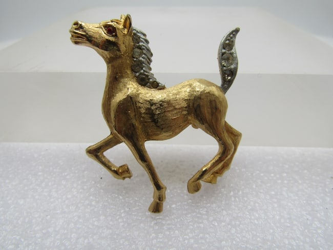 Vintage Two Tone Horse Brooch, Rhinestones, 1960's: DescriptionVintage Two Tone Horse Brooch, Rhinestones, 1960's, Textured gold tone horse with silver tone main and tail that are set with clear rhinestones. Red rhinestone eye. The horse is in a trotti