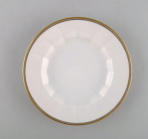 Royal Copenhagen. Three porcelain plates with gold border.