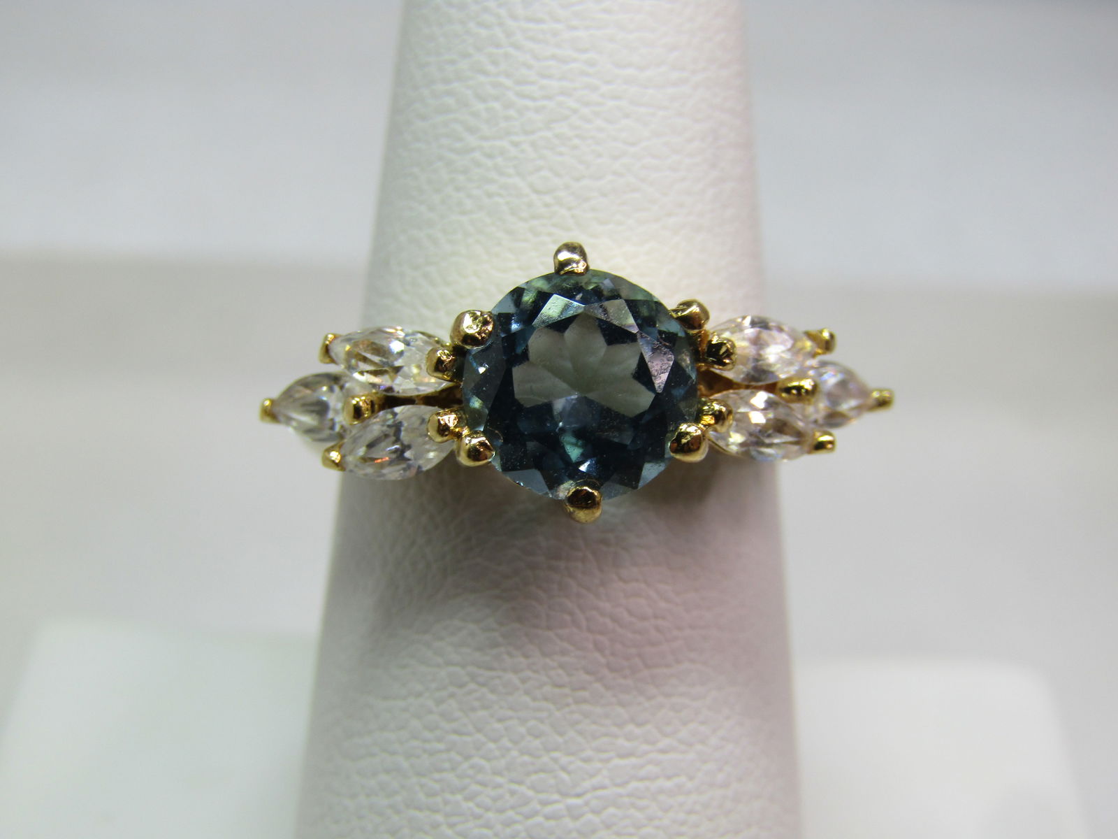Blue Topaz & Clear Stone Ring, Sz. 8. Signed, 1980's-1990's: Blue Topaz & Clear Stone Ring, Sz. 8. Signed, 1980's-1990's. The ring is gold tone and marked .925 but is magnetic and therefore believed to be mismarked. It is signed PAJ. The center blue 7.5mm round