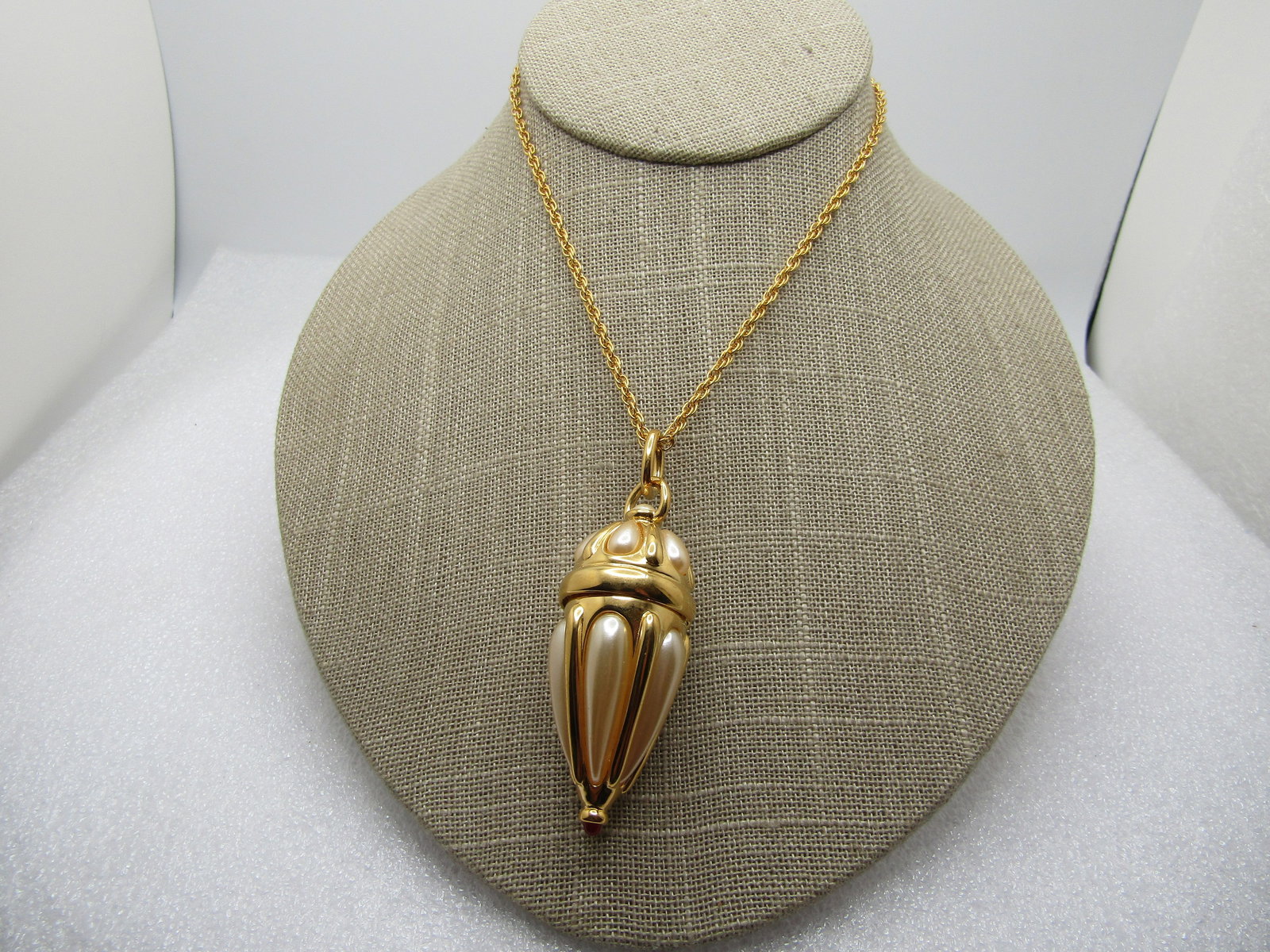 Vintage Joan Rivers Pill Box Locket Necklace, 34", Faux Pearl, 1990's: Vintage Joan Rivers Pill Box Locket Necklace, 34", Faux Pearl, 1990's. This has a gold tone faux pearl long drop locket/pill box with hinged lid and a red stone on the bottom tip. The locket drop is a