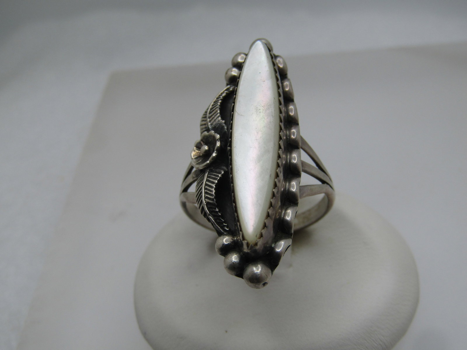 Vintage Sterling Southwestern MOP Ring, Floral/Feather Accents, Sz. 9, 1970's-1980's: Vintage Sterling Southwestern MOP Ring, Floral/Feather Accents, Sz. 9, 1970's-1980's. This is an elongated pointed mother-of-pearl that is set raised above a sawtooth bezel setting. The stone is appx.