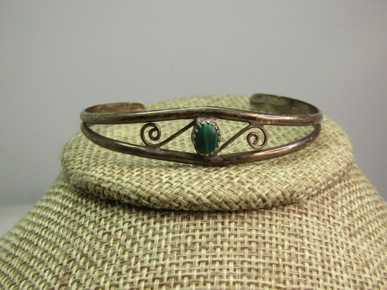 Vintage Sterling Southwestern Malacite Cuff Bracelet, 6.5", 1960's-1970's: Vintage Sterling Southwestern Malacite Cuff Bracelet, 6.5". This has an elongated open diamond stape on top with two scrolls - one on each side of the sawtooth bezel-set malachite stone that is app. 7