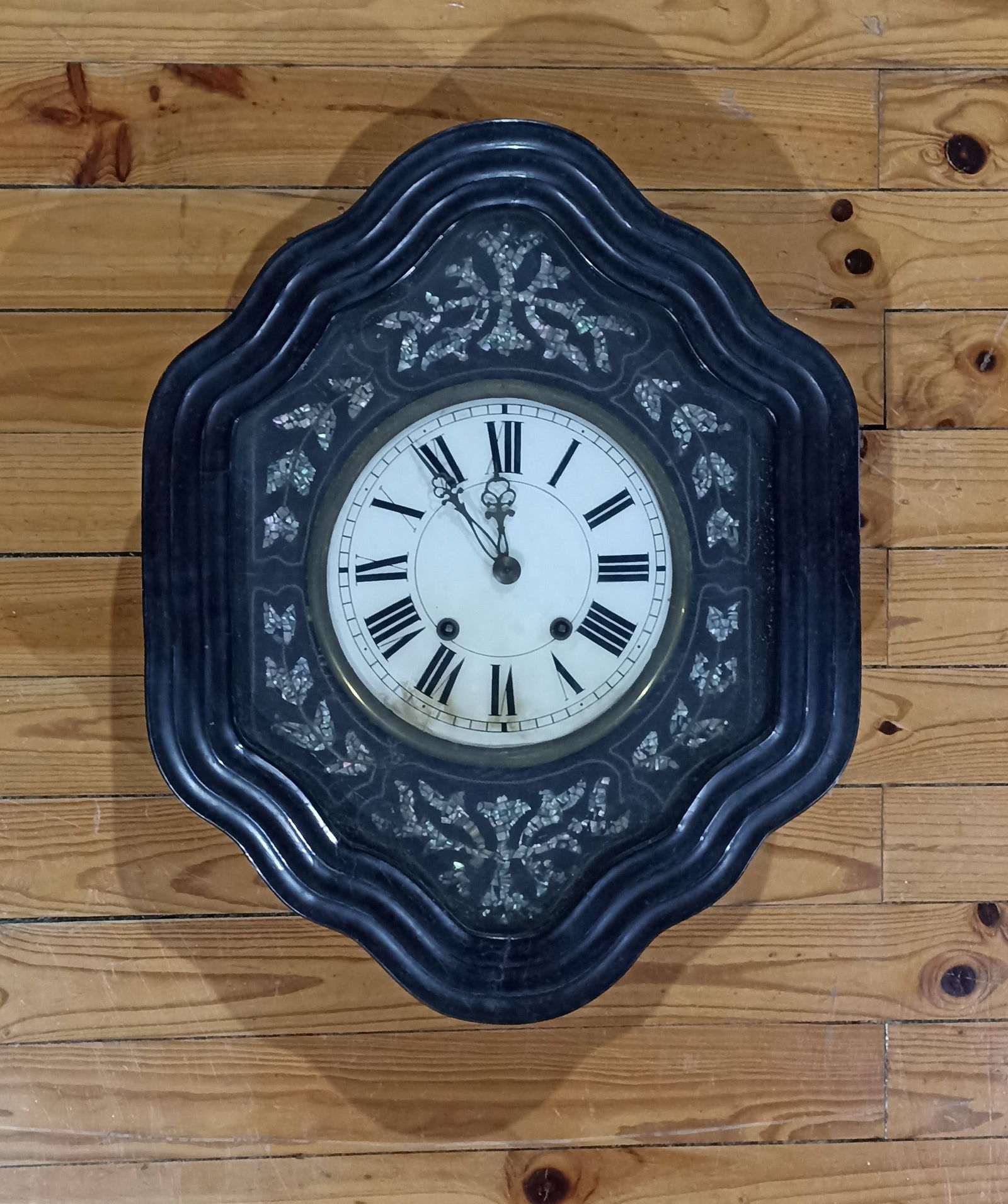NAPOLEON III WALL CLOCK: Description: NAPOLEON III WALL CLOCK. 19th-century French, black lacquered wood with mother-of-pearl inlay. Glass dial. Dimensions: 60 x 50 cm. Date/Period: Unknown Materials: Glass, Pearl, Wood Reser