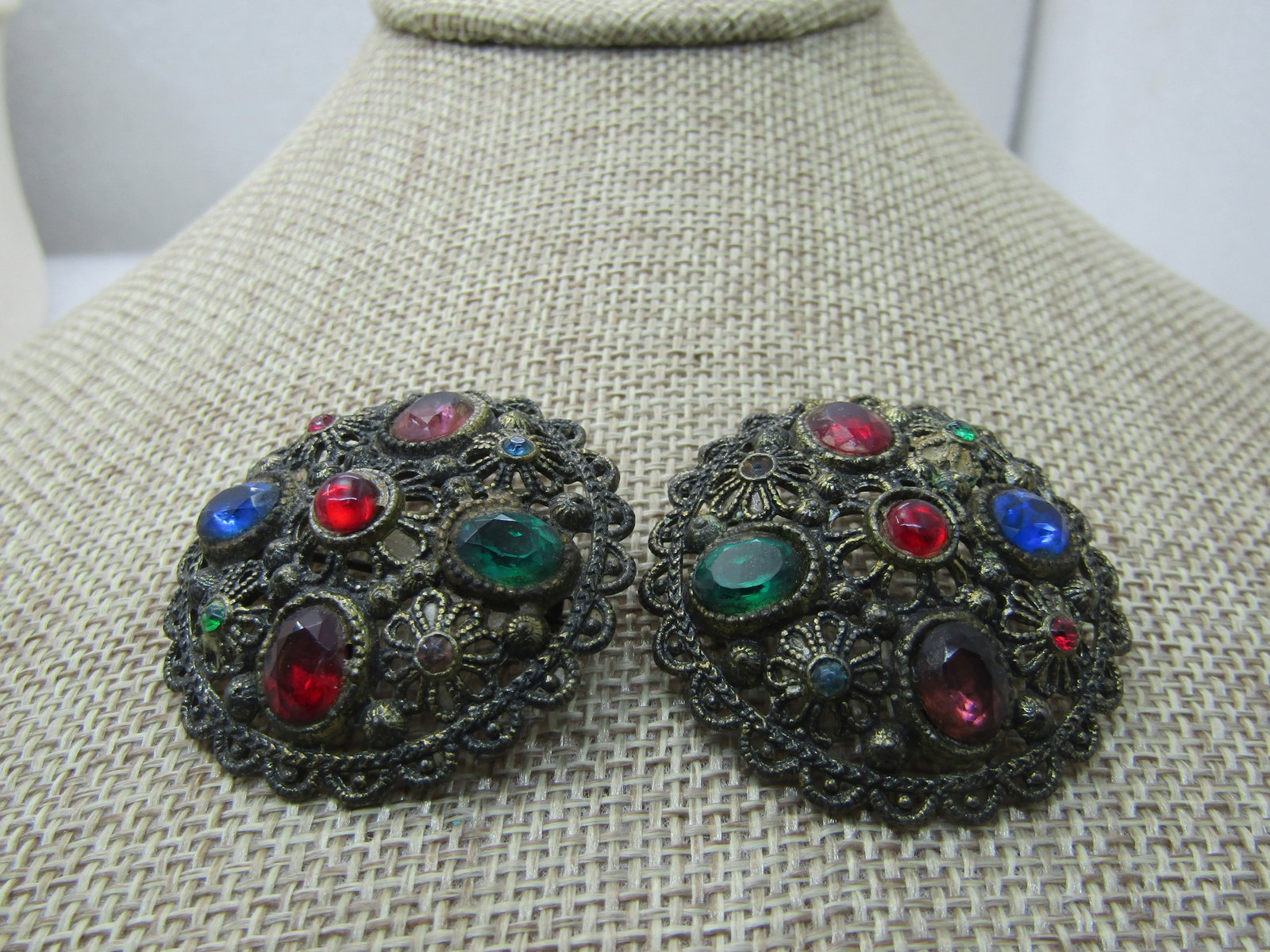 Vintage Pair Early 1900 Brooches, Filigree with Rhinestones: Vintage Pair Early 1900 Brooches, Filigree with Rhinestones, 1.5" domed. Scalloped edge, C-Clasp. 1920's-1930's. Darkened brass look. Glass faceted andR ounded stones. Red, blue, green, pink. Vintage 