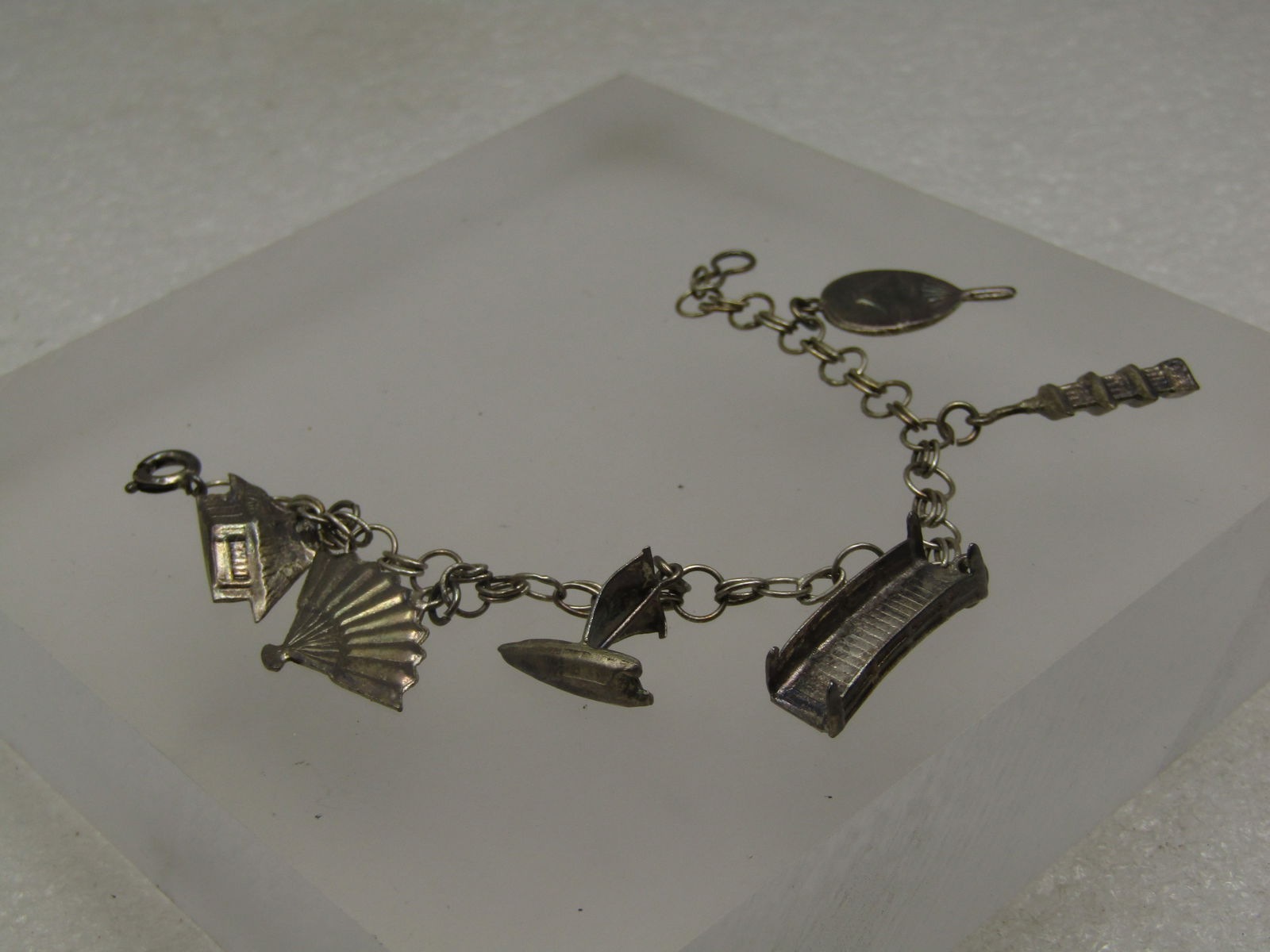 Vintage Sterling Japanese Charm Bracelet, 1950's, Original Box 6": Vintage Sterling Japanese Charm Bracelet, 1950's, Original Box 6". Appx. 4.5mm wide round linke with a double oval connector link, spring clasp. This has a geisha fan, pagoda, bridge, boat, fan, and b