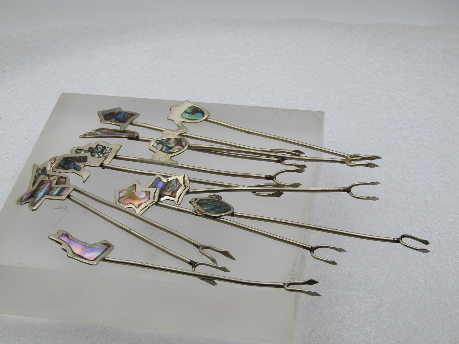 Vintage 12 Inlaid Abalone Mexican Cocktail Forks, Alpaca: Title: Vintage 12 Inlaid Abalone Mexican Cocktail Forks, Alpaca Description: Vintage 12 Inlaid Abalone Mexican Cocktail Forks, Alpaca. Varioud designs, donkey head, poultry, foot, what looks like stat