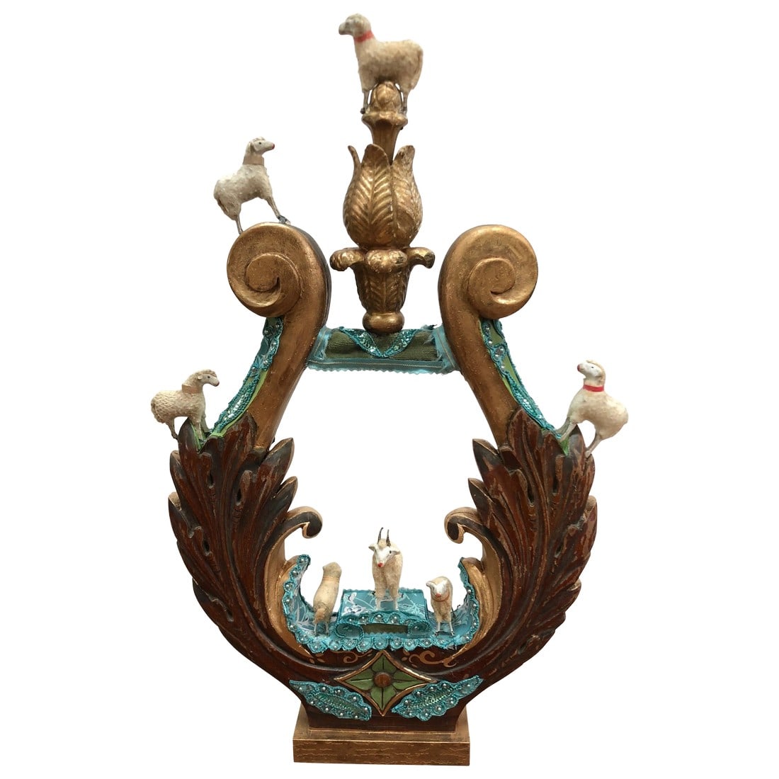 Lyre Fragment Transformed to Mixed-Media Sculpture: A charming imaginative sculpture created on a vintage carved wood fragment in the shape of a lyre, intricately adorned with European handmade antique lambs, an old finial, a mix of fabrics and hand pa
