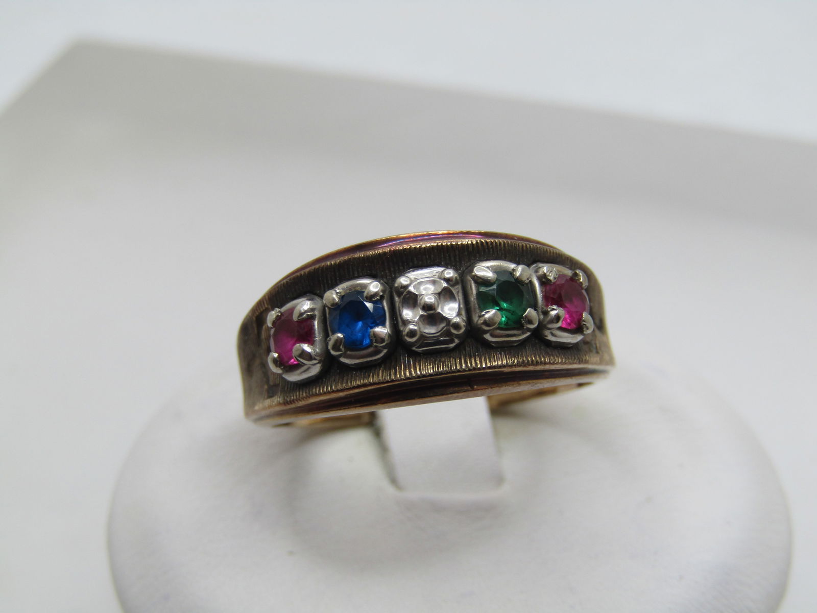 Vintage 10kt Mother's Ring, Sz. 8.25, Mixed Gemstones, Signed DC, 1960's-1970's: Vintage 10kt Mother's Ring, Sz. 8.25, Mixed Gemstones, Signed DC. This has four appx. 3mm gemstones: two ruby, one emerald, and a blue spinel. The center stone is an illusion of a stone. May be left w